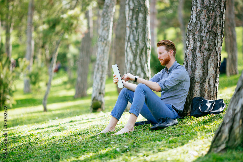 Businessman using tablet in park