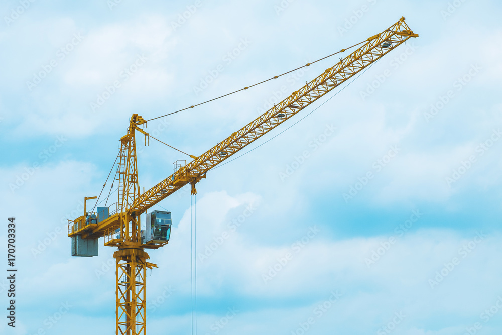 A large crane is working on blue sky background