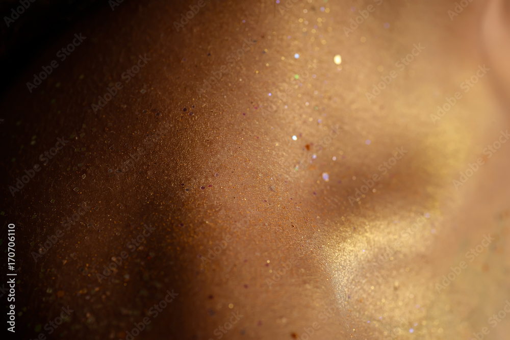 Closeup human skin with golden makeup. Selected focus with depth of field.