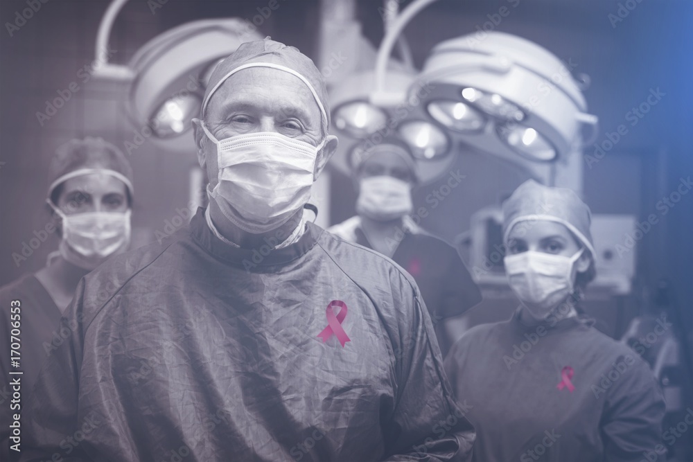 Composite image of smiling surgeon posing with a team Composite image of smiling surgeon posing with a team
