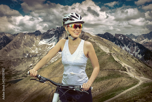 Beautiful woman in helmet and glasses stay on the bicycle around