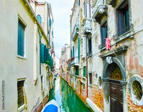 The blurred image of picture of the venetian canals with boats across canal