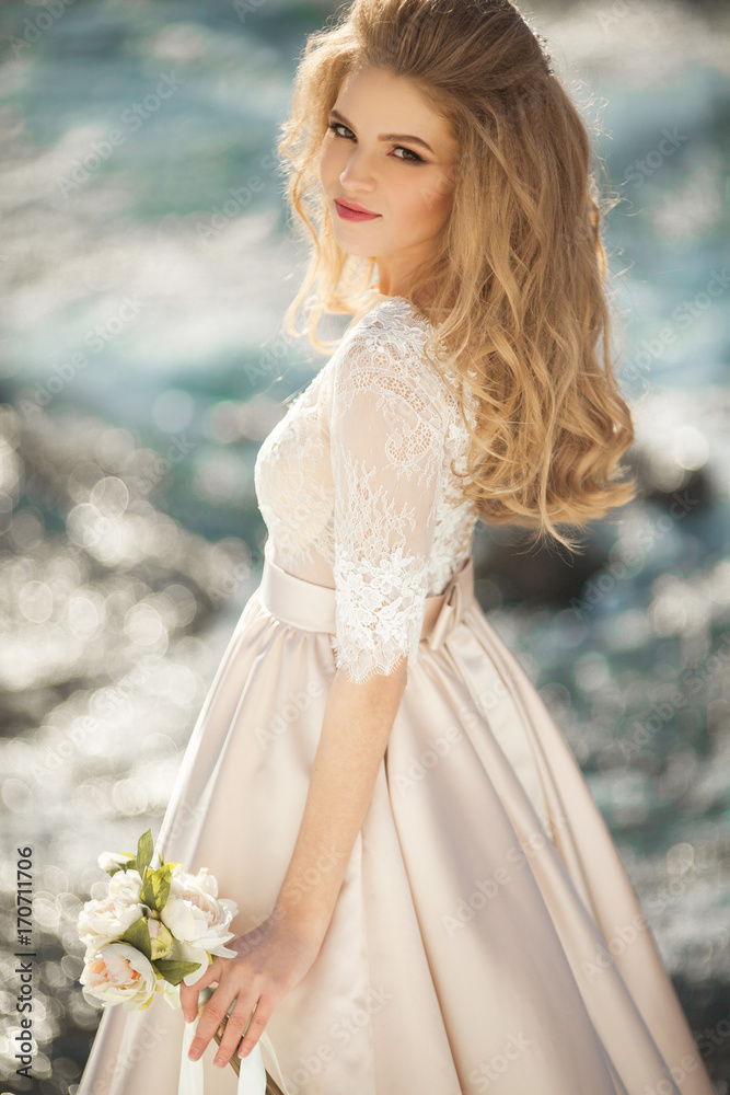Beautiful young girl in a chic dress in the nature next to the river Beautiful young girl in a chic dress in the nature next to the river
