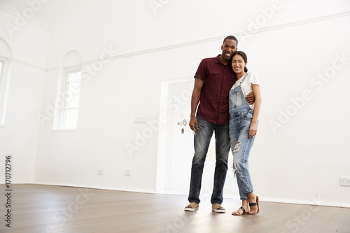 Portrait Of Excited Young Couple Moving Into New Home Together