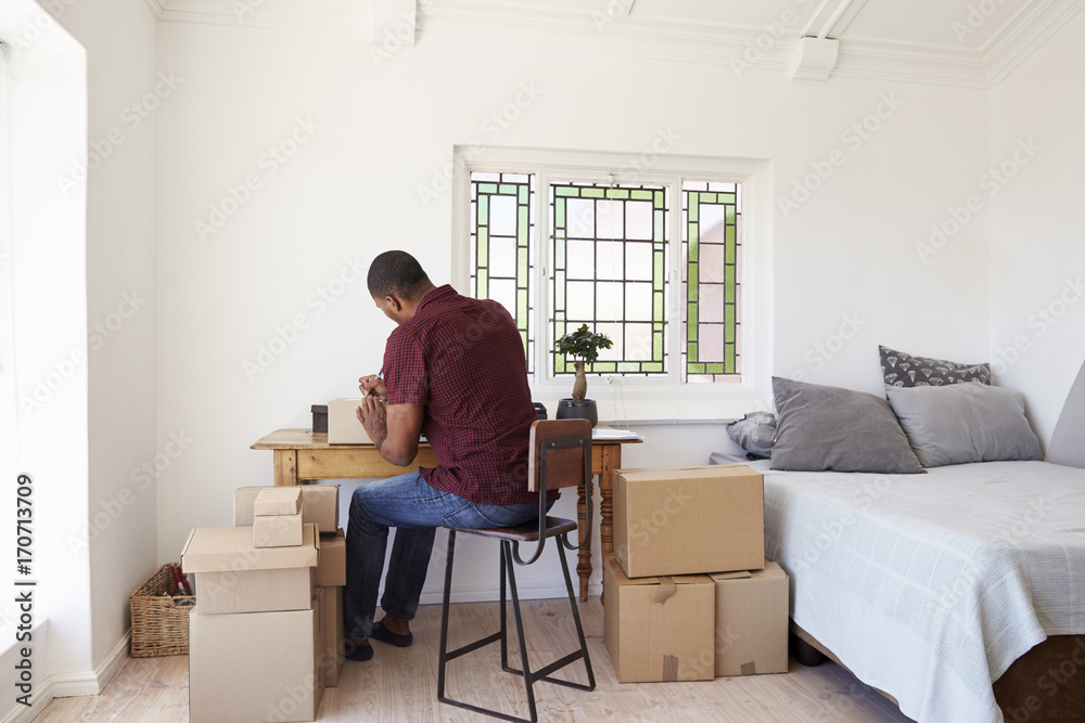 Man In Bedroom Running Business From Home Labeling Goods