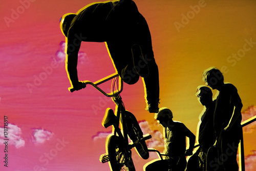 Bikers jumping on a ramp in the park