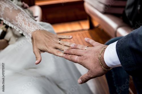 groom and bride touch their hands with wedding ring