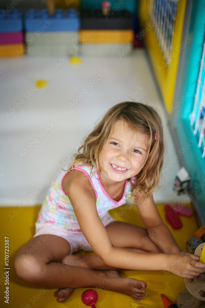 Little girl in playground. Caucasian girl playing with toy. Looking at camera. Little girl in playground. Caucasian girl playing with toy. Looking at camera.