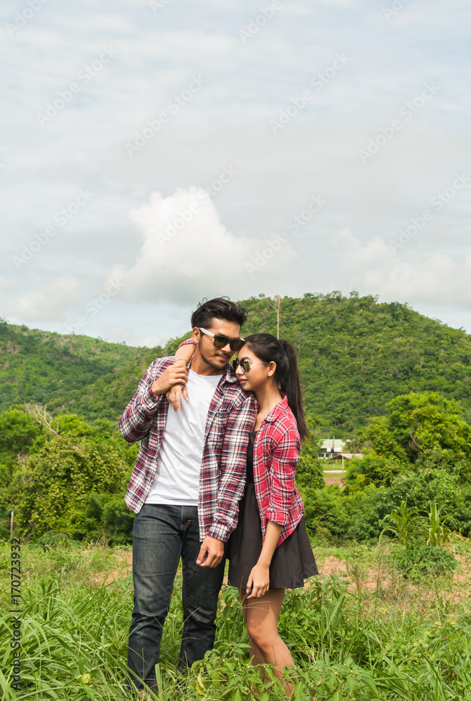 Couple of romantic lovers standing in nature . Asian handsome man and beautiful girl is travel , hipster people falling in love happiness time, vintage tone and lifestyle concept