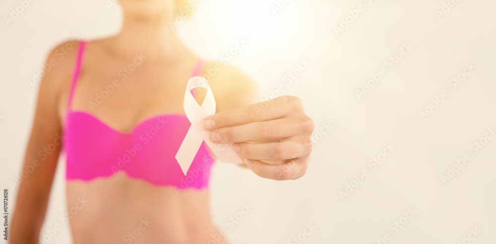 Mid section of woman in pink bra holding ribbon