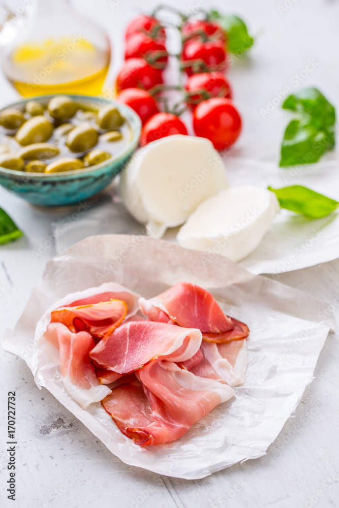 Prosciutto Olives olive oil mozzarella cheese tomatoes basil -  ingredients italian or mediterranean cuisine.
