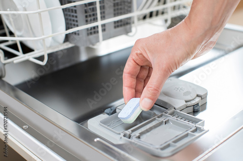 Foto Close Up Of Woman Putting Detergent Tablet Into Dishwater
