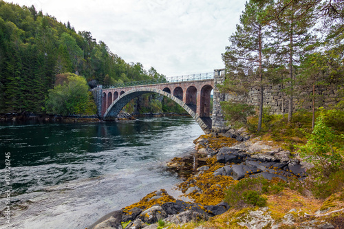 Bridge mirroring in water - sunny day near Alesund, Norway