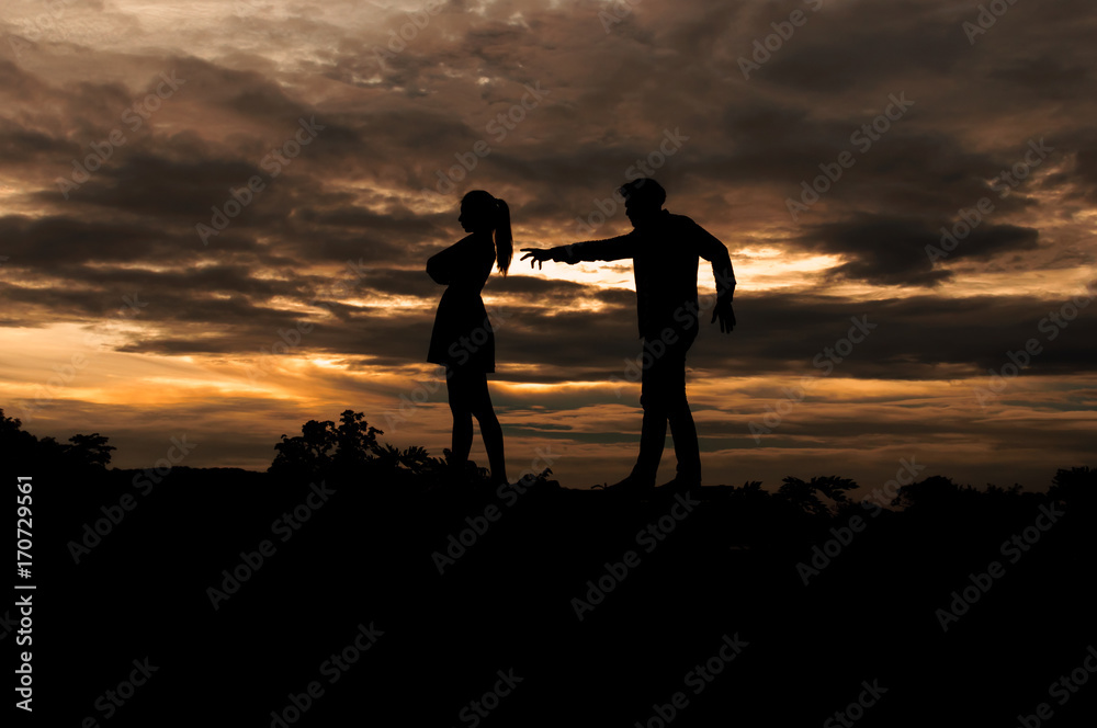 Silhouette couple in love ,man and women are quarrel in nature ,sky with clouds in sunset time,pastel and vintage tone