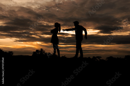 Silhouette couple in love ,man and women are quarrel in nature ,sky with clouds in sunset time,pastel and vintage tone