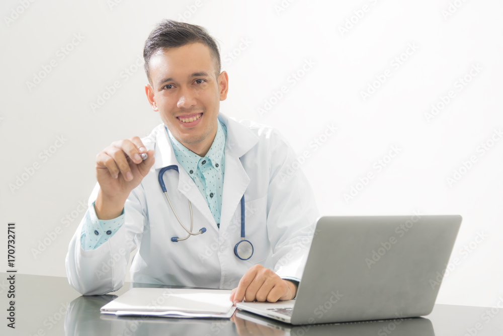 Doctor hand with a pen pointing on white with labtop on desk ,selective focus at doctor ,isolated on white Doctor hand with a pen pointing on white with labtop on desk ,selective focus at doctor ,isolated on white