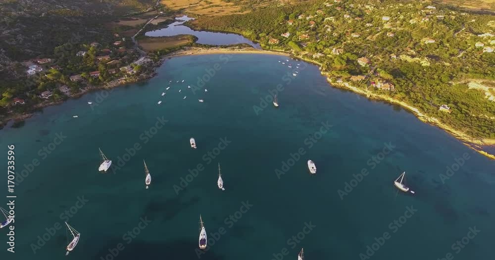 Aerial, beautiful bay with some anchored boats and yachts and crystalline water on sunrise Aerial, beautiful bay with some anchored boats and yachts and crystalline water on sunrise
