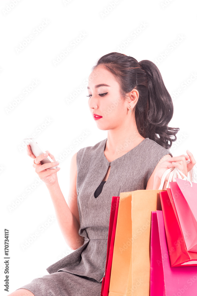 Cheerful shopping women of Asian holding bags with smart-phone isolated on white ,portrait beautiful business women in studio Cheerful shopping women of Asian holding bags with smart-phone isolated on white ,portrait beautiful business women in studio