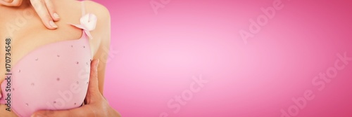 Composite image of mid section of woman wearing pink bra for
