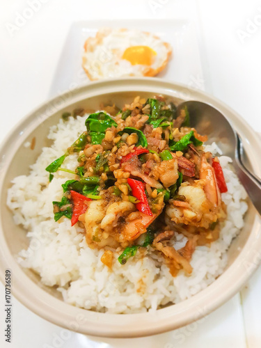 Spicy fried shrimp with basil leaves on cooked rice