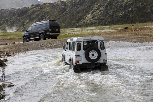 two vehicles fording river in nature park landmannalaugar in iceland