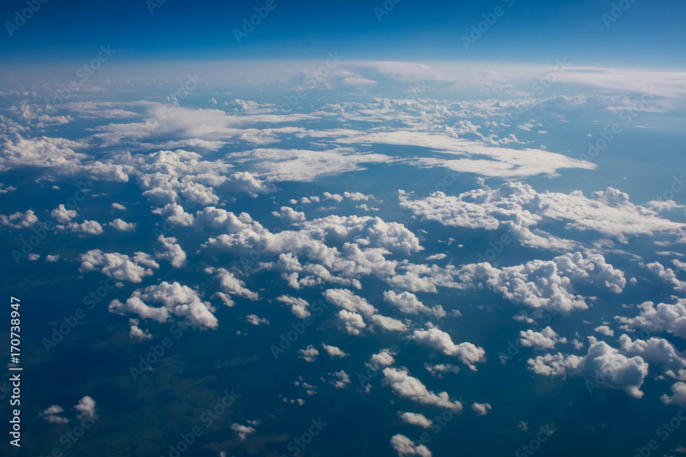 views of clouds and land from airplane window