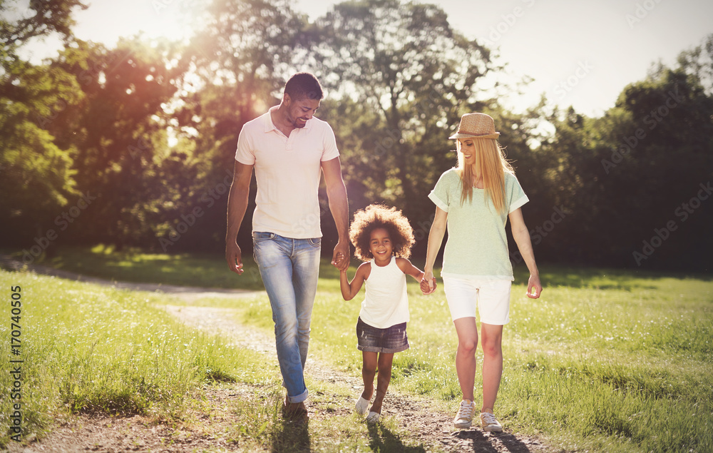 Fototapeta premium Happy family walking in nature with child