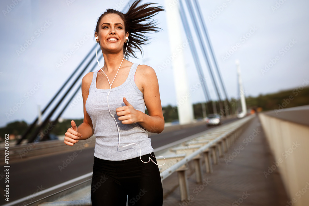 Pretty female jogger running outdoors