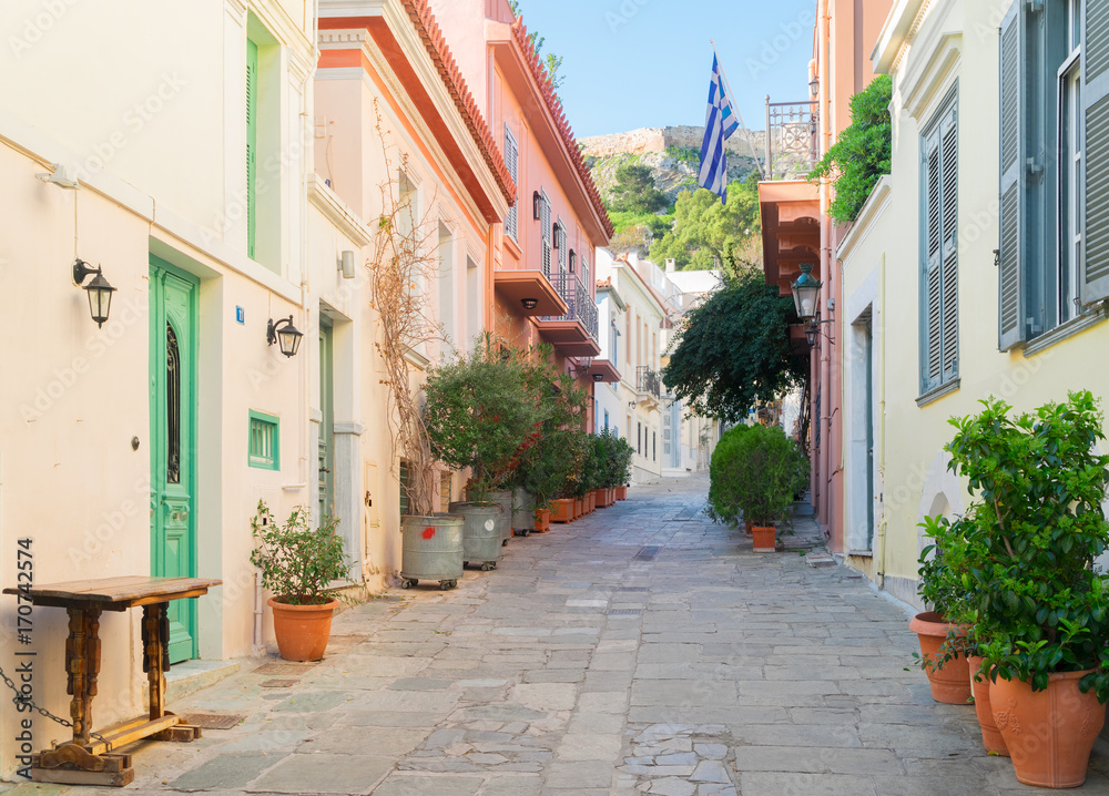 small paved street of Placa district with Acropolis hill in Athens, Greece