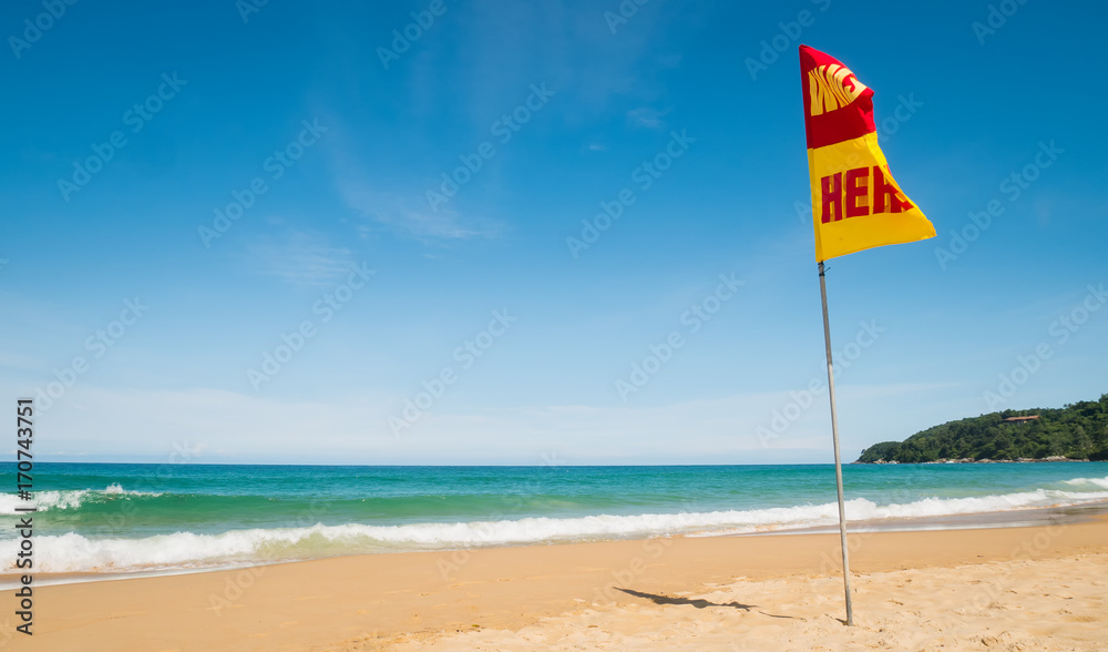 A word Swin Here on the red and yellow flags on the beach.To tell the point safe for swimming In security concept.