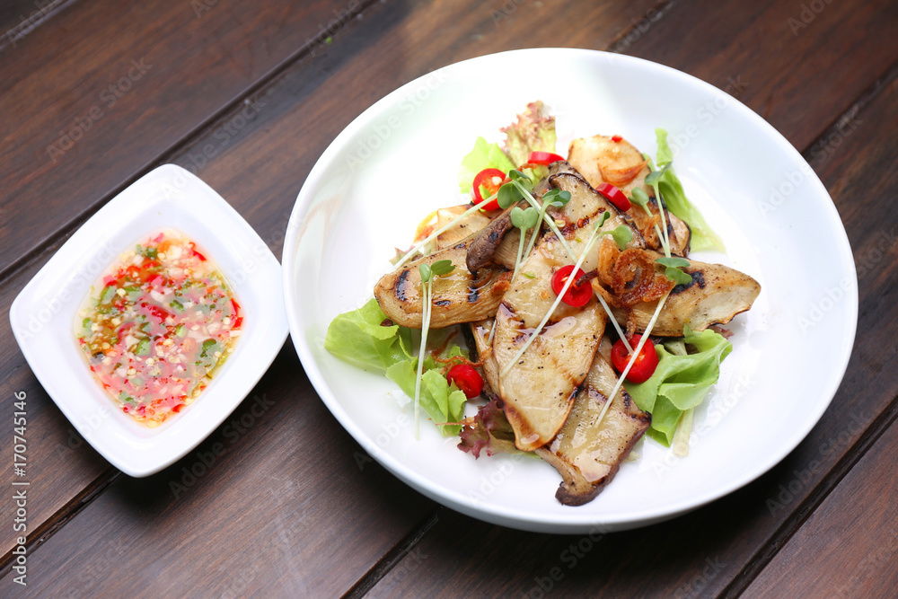 Grilled King Oyster Mushroom , Eryngii slices with sunflower sprout and green oak lettuce on white bowl Grilled King Oyster Mushroom , Eryngii slices with sunflower sprout and green oak lettuce on white bowl