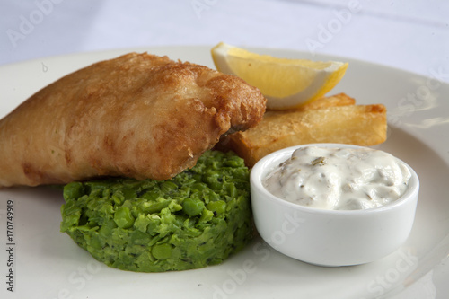 Canvas Print A meal of battered fish and chips with mushy peas and tartare sauce