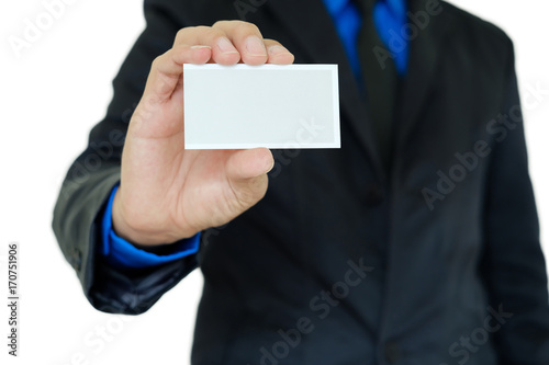 Businessman in black suit showing business card with right hand on white background with clipping path.