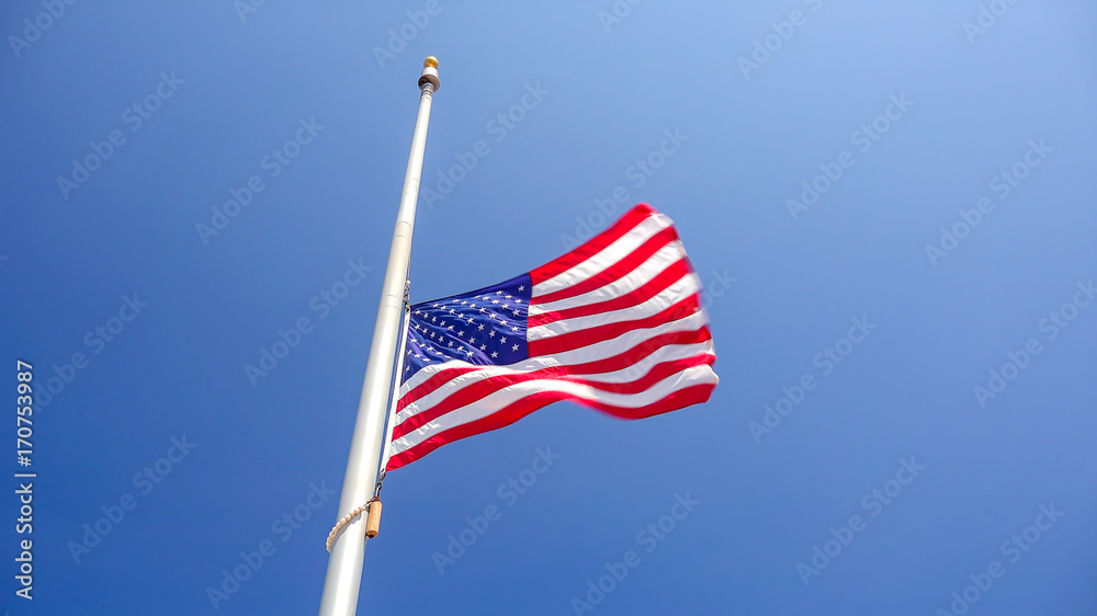 American Flag at Half Mast aka Half Staff Against Clear Blue Sky