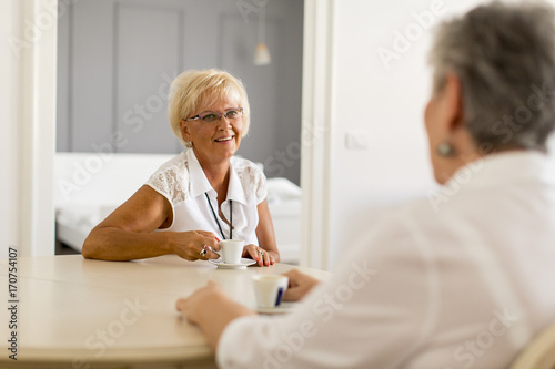 Two older women drinking co...