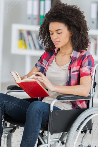 woman in wheelchair reading a book
