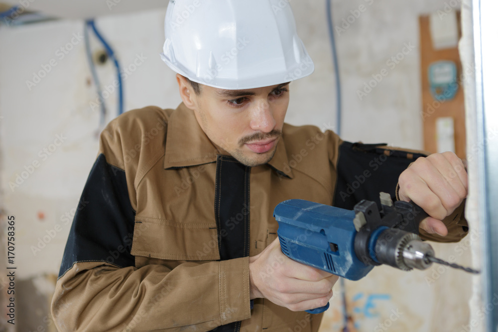 young buider drilling the wall with drill perforator young buider drilling the wall with drill perforator