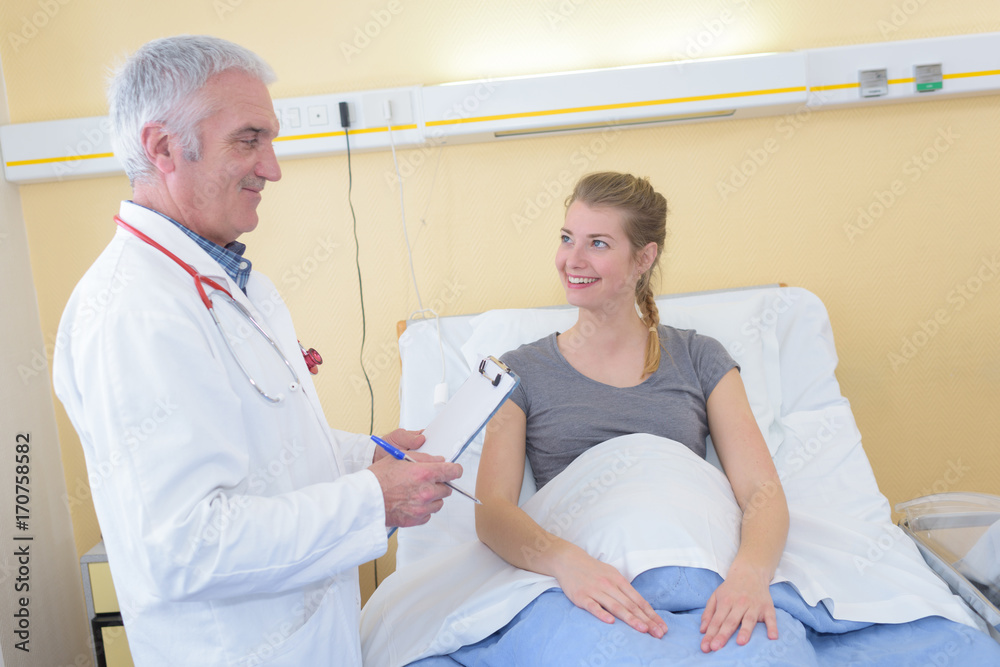 Obraz premium senior male doctor talking to female patient in hospital