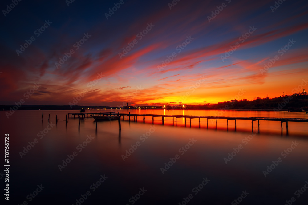 Wooden Dock and fishing boat at the lake, sunset shot