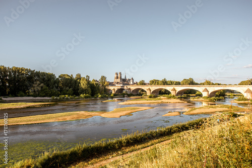 Landscape view on the river and old arch bridge in Orleans city during the sunset in France photo