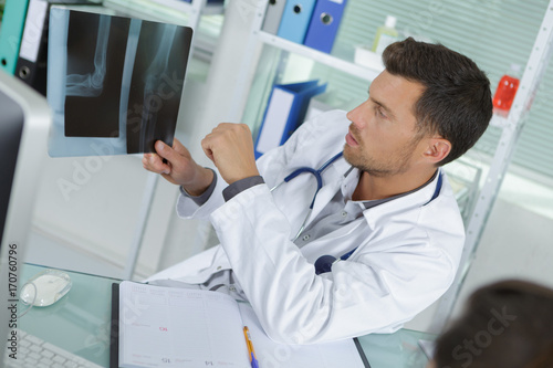 male radiologist looking at x-ray with patient