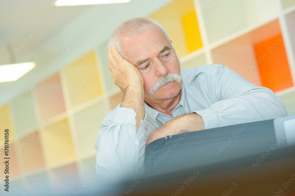 Fototapeta premium elderly man with hand on his temple has a headache
