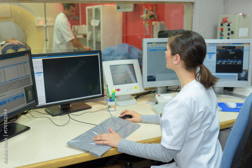 nurse using computer at reception desk in hospital