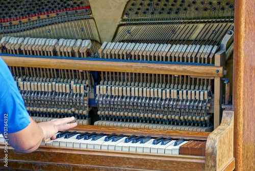 рука человека нажимает на клавиши в открытом пианино