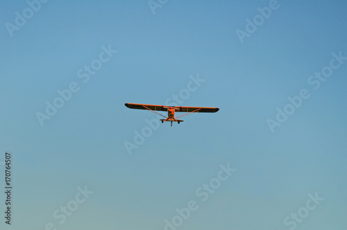 yellow single engine monoplane approaching for landing