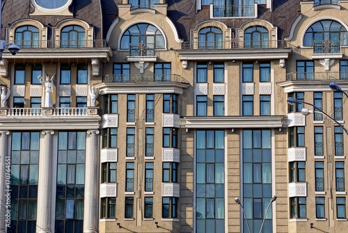 серо коричневый фасад многоэтажного здания с балконами и окнами