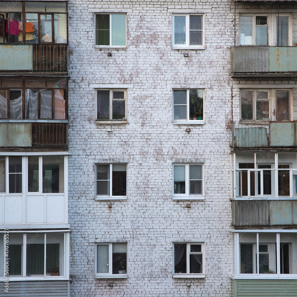 Windows and balconies of the old brick apartment building in Russia