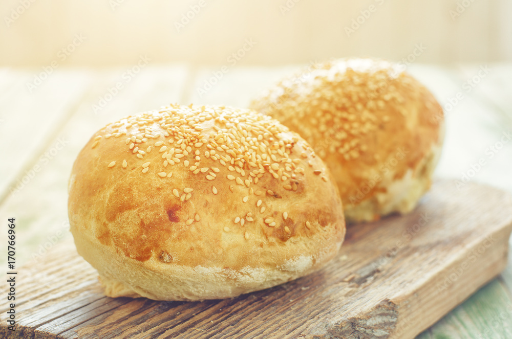 homemade buns for burger on wood cutting board. sunlight on background homemade buns for burger on wood cutting board. sunlight on background