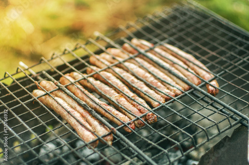 close up grilled sausages on bbq in sunlight. selective focus 