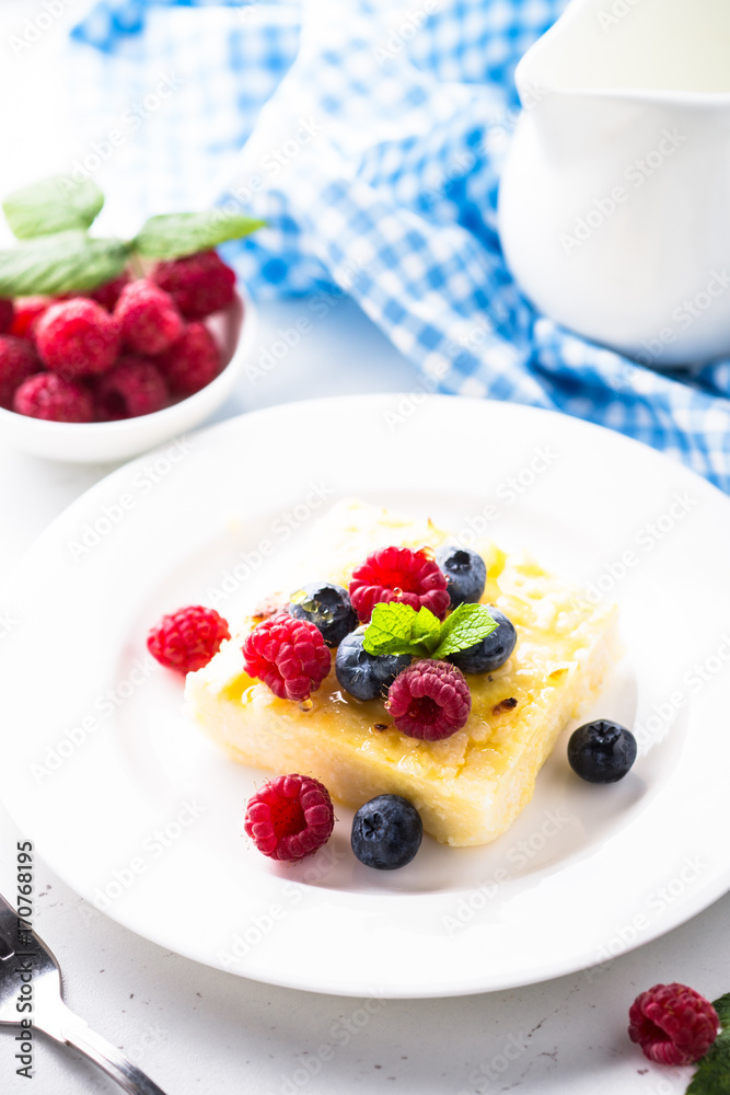Cheesecake with fresh berries on white plate. Healthy breakfast. Cheesecake with fresh berries on white plate. Healthy breakfast.